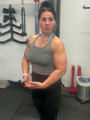June 2026 A muscular woman in a gym, confidently posing with her arms flexed.